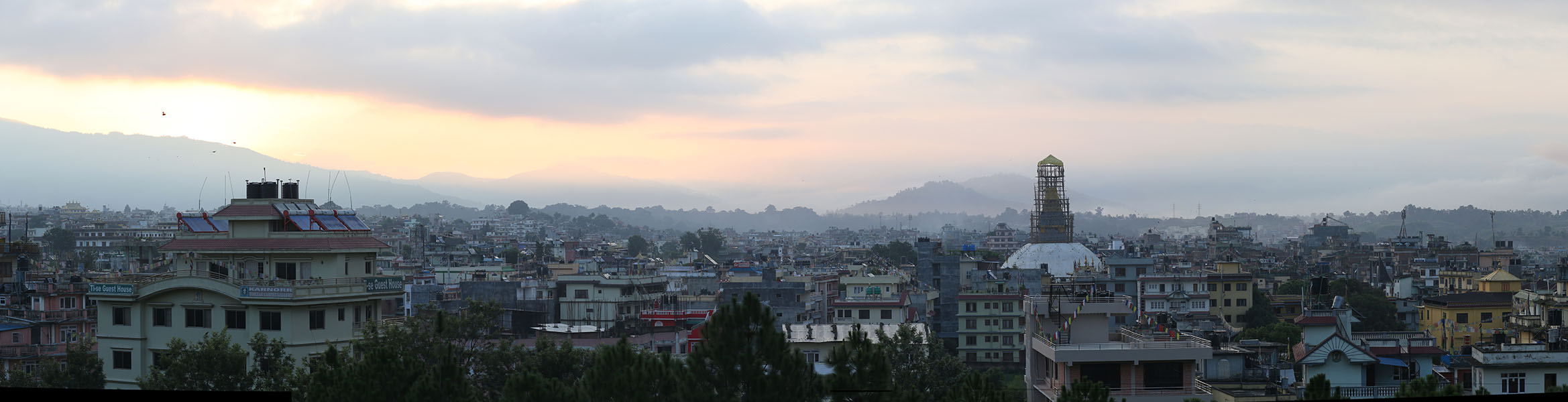 Panoramic View of Kathmandu Neighborhood with Large Stupa at Sunset.